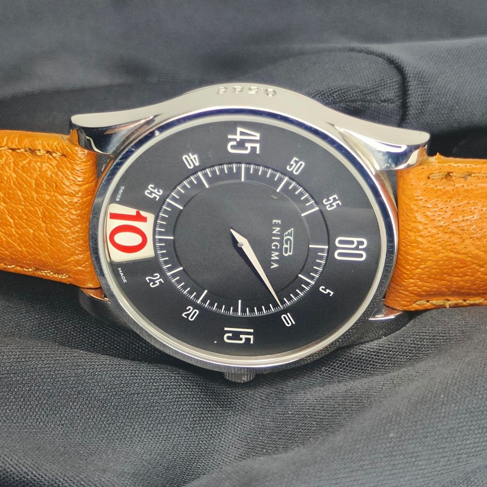 Primo piano del quadrante nero dell'orologio Gianni Bulgari Enigma con indicazione dei minuti e logo GB.