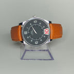 Orologio di lusso Gianni Bulgari Enigma esposto su supporto trasparente, cinturino cuoio a contrasto.